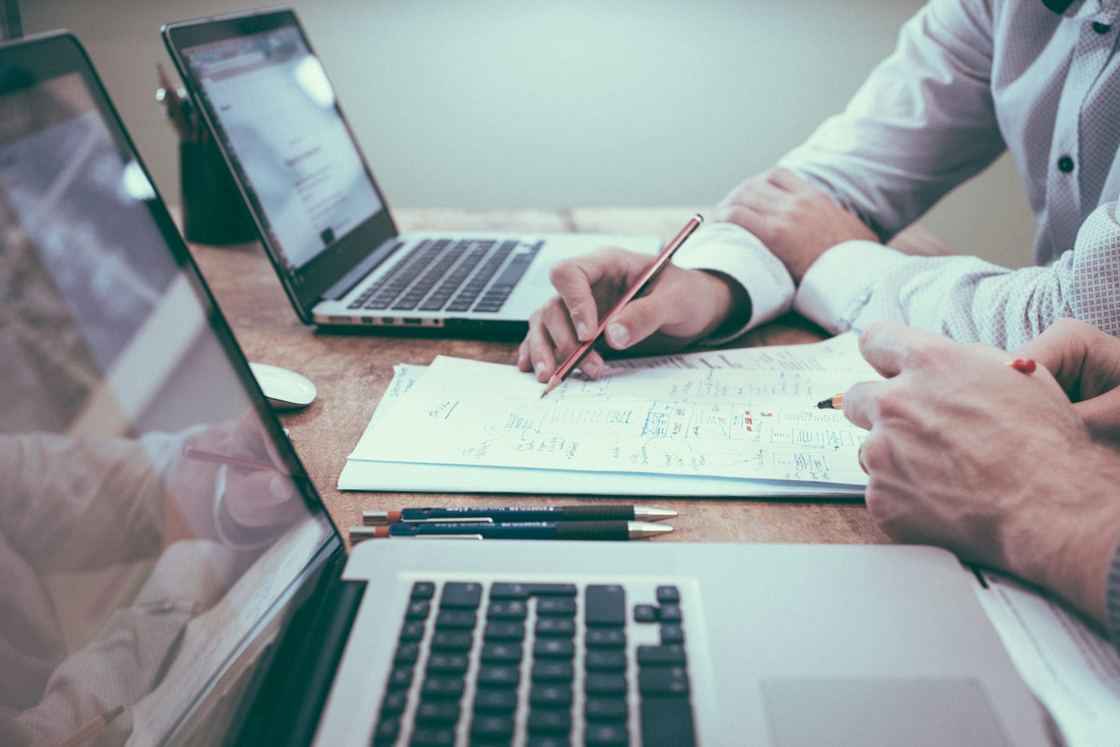 Bureau couvert de documents avec un ordinateur portable ouvert