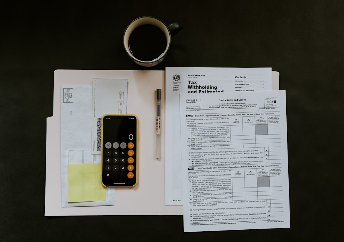 Spécialiste effectuant la conciliation bancaire avec calculatrice et rapports financiers